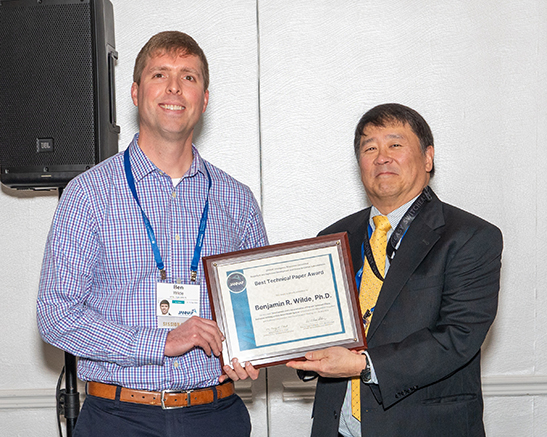 Benjamin R. Wilde, PhD, accepts the PEDCS Best Paper Award from JANNAF TEC Chair, Frank Tse.