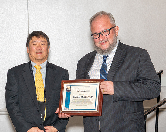 JANNAF TEC Chair, Frank Tse, presents a certificate to Mark Mason, PhD, recognizing his selection as a JANNAF Fellow.